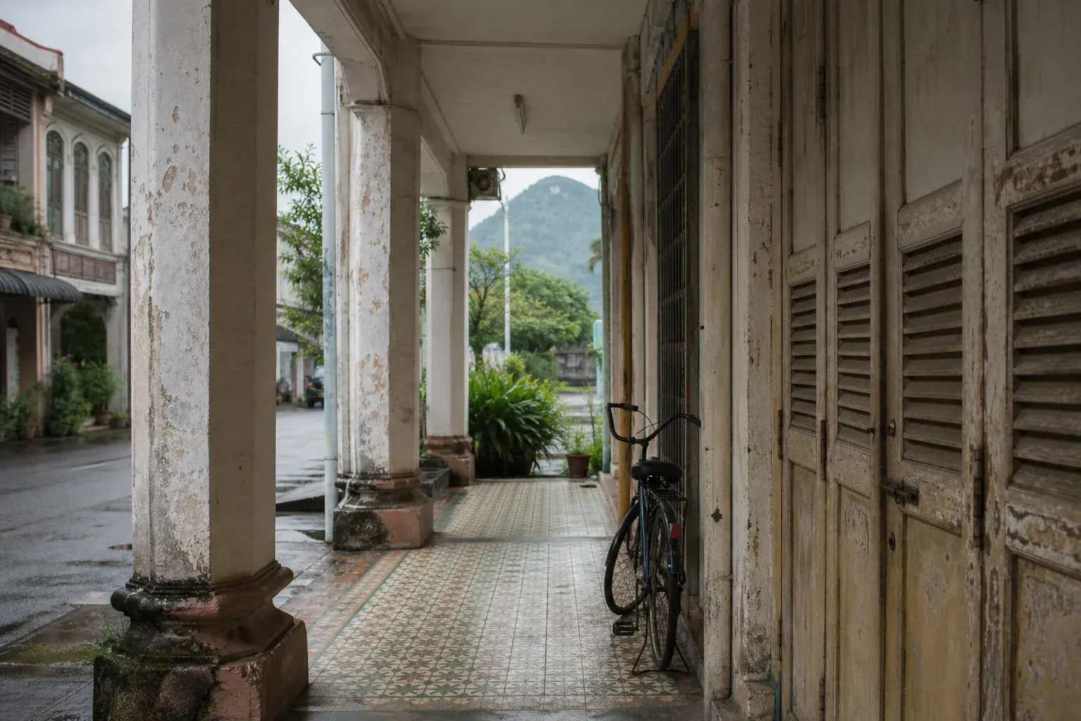 AI-generated editorial interpretation of a quiet covered shophouse walkway in Kluang after rain